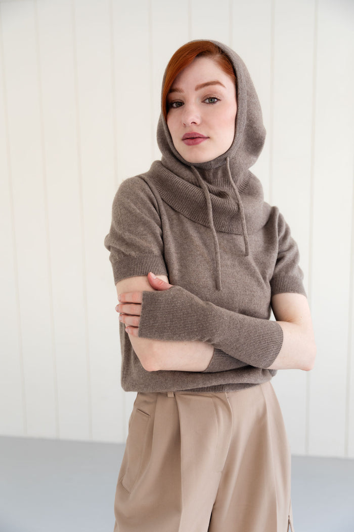 Woman wearing a cashmere balaclava, paired with similar arm warmers, and short sleeve cashmere top.