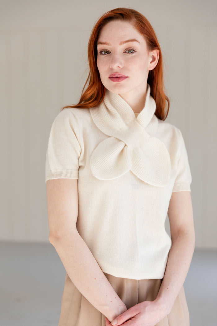 Woman wearing a 100% Mongolian cashmere mini scarf in natural white with matching cashmere top.