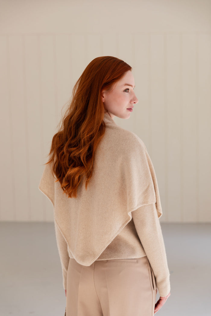 Woman wearing a beige cashmere triangle scarf and trousers