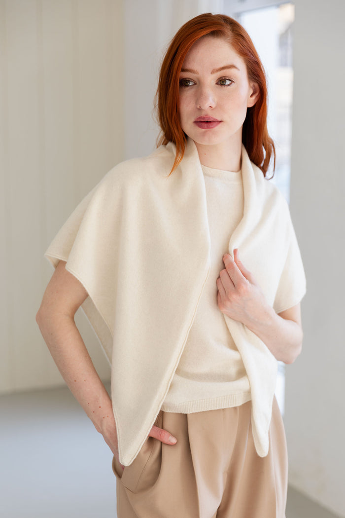 Woman wearing a white triangle scarf and beige pants
