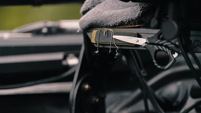 Cling Tool Stick Mini attached inside a fishing boat, holding fishing hooks and jigs with a textured grip and compact design for easy access during fishing trips.