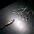 Hover X fishing lure with multiple shiny, silver metal spinner blades attached to a central frame, designed to attract fish with flashy movement and reflection.