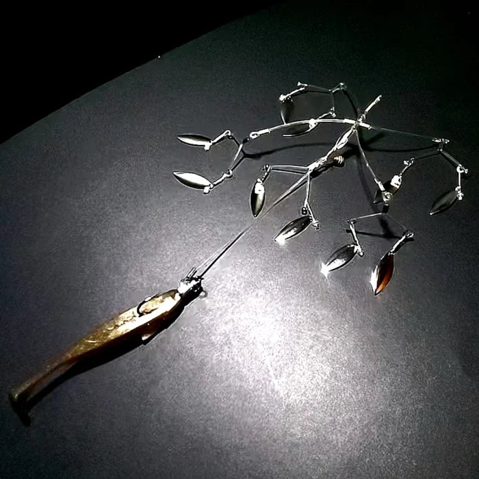 Hover X fishing lure with multiple shiny, silver metal spinner blades attached to a central frame, designed to attract fish with flashy movement and reflection.