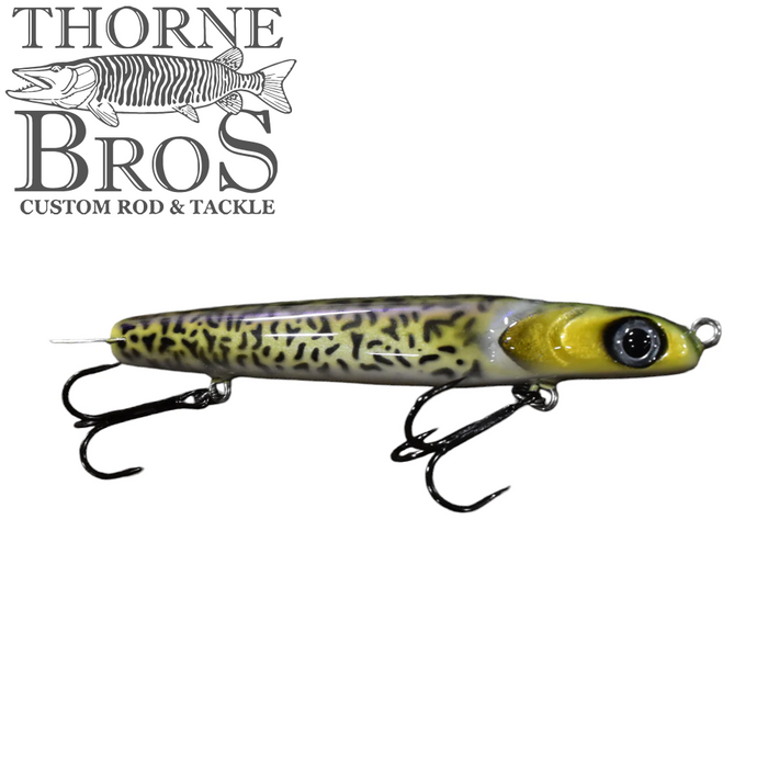 Kodiak Navin fishing lure designed with a yellow and black spotted pattern, featuring two sharp treble hooks and realistic eye details for effective fishing tackle use.