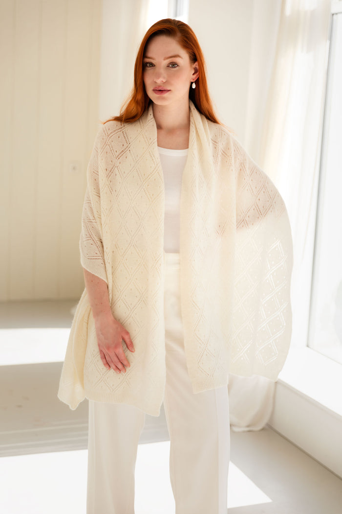 Woman wearing a white 100% Mongolian cashmere pointelle shawl.