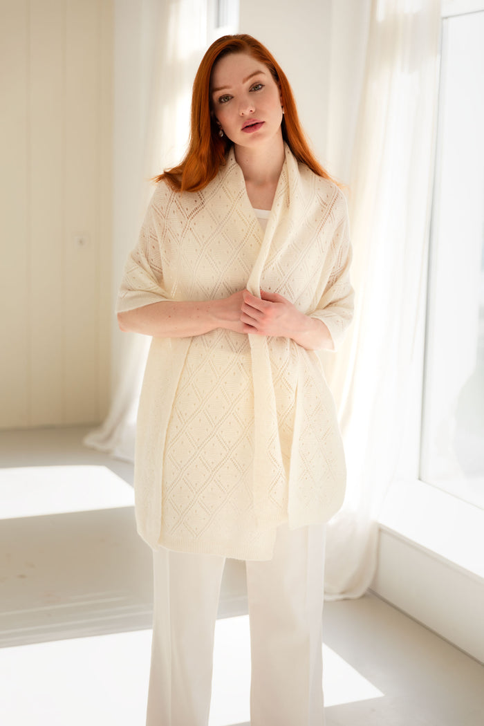 Woman wearing a 100% Mongolian cashmere pointelle shawl in white.