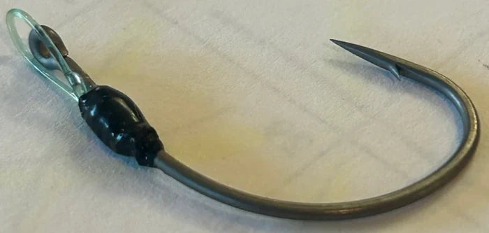 Close-up of Limitless Felix's HALO Ryugi fishing hook featuring a sharp curved point and durable black and metallic finish, designed for musky and ice fishing tackle.