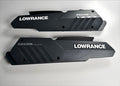 Black plastic Lowrance Recon Sideplate Kit Freshwater PN:000-16389-001 components with textured and smooth surfaces, featuring white Lowrance and Recon branding, designed for fishing tackle customization.