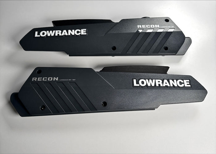 Black plastic Lowrance Recon Sideplate Kit Freshwater PN:000-16389-001 components with textured and smooth surfaces, featuring white Lowrance and Recon branding, designed for fishing tackle customization.