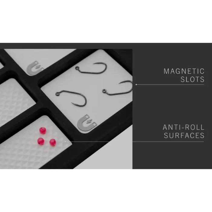 Close-up of the MFC Fly Tying Mat showing magnetic slots holding fishing hooks and anti-roll textured surfaces designed to keep small fly fishing materials securely in place.