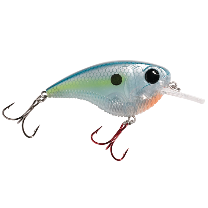 Monsterbass Flatline fishing lure with a translucent blue and green body, detailed scale pattern, large black eye, and two sharp treble hooks for effective fishing tackle.