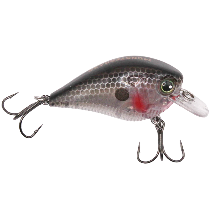 Monsterbass Little Banger fishing lure in black and gray with honeycomb scale pattern, realistic eyes, red gill detail, and two treble hooks for freshwater fishing tackle.