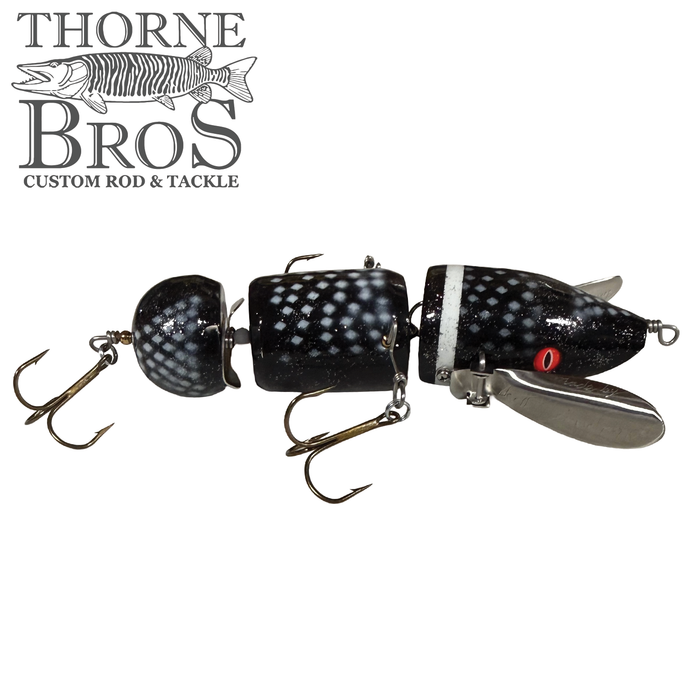 Musky Safari Franken Spitz fishing lure with black and white segmented body, red eyes, and metal propeller blades, designed for musky fishing tackle enthusiasts.