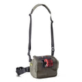 Orvis Chest/Hip Pack in olive green with adjustable shoulder and waist straps plus a front pocket holding a red fishing line spool