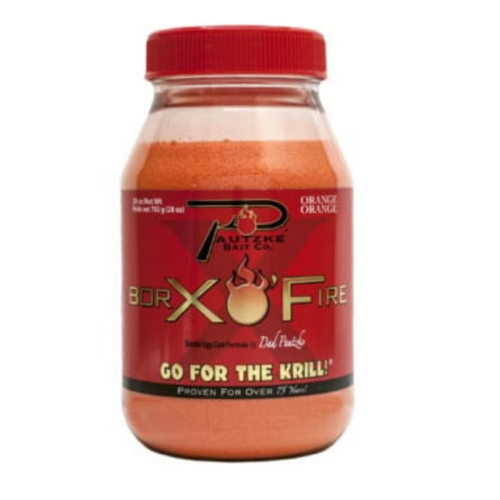 Clear plastic jar with a red lid containing bright orange fishing attractant powder labeled Pautzke BorX O'Fire 28oz, designed for enhancing fishing tackle effectiveness.