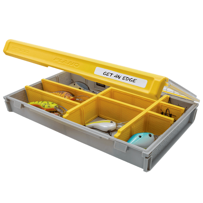 Plano EDGE 3700 Flex fishing tackle box with yellow lid and multiple compartments containing various fishing lures, designed for organized storage of fishing gear.
