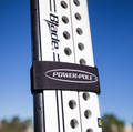 Close-up of a black Power-Pole Travel Strap For All Power-Pole Models SKU:TRAVEL-STRAP-F securing a white fishing tackle blade against a clear blue sky background.