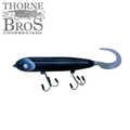 Holmgren Serpent Musky Top Water fishing lure in dark blue with a curled tail and two sets of sharp treble hooks, designed for top water musky fishing.