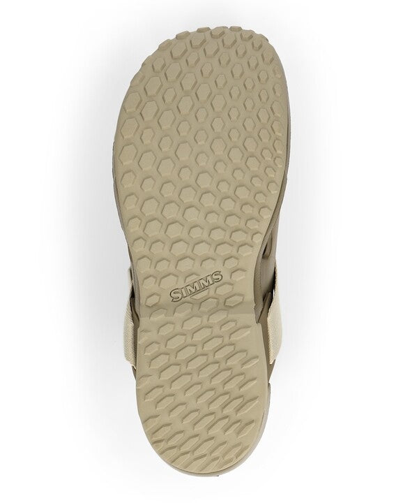 Sole view of the Simms Drifter AT sandal showing a beige rubber outsole with hexagonal tread pattern and the Simms logo embossed in the center for traction and durability.