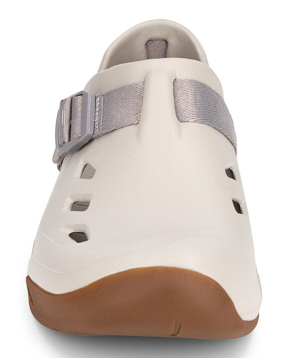 Simms Drifter fishing shoe in light tan with a brown sole and adjustable gray strap, featuring ventilation cutouts for breathability and water drainage.