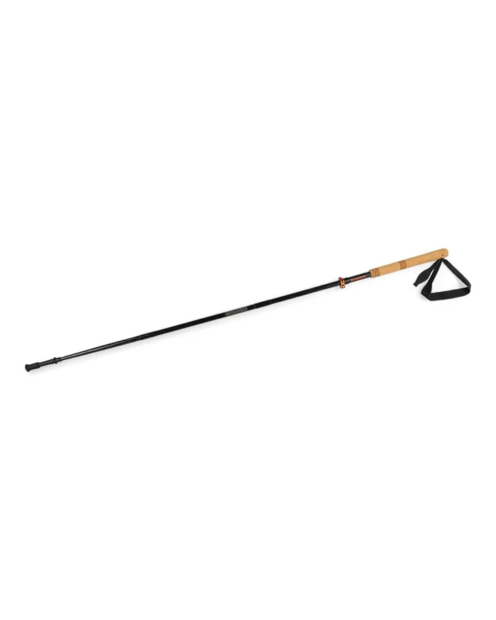 Simms Pro Wading Staff with a black shaft, cork handle, and adjustable wrist strap designed for stability and support during fly fishing in rugged water environments.