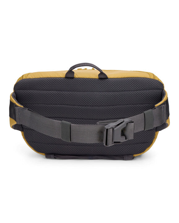 Simms Tributary Hip Pack shown from the back, featuring a padded mesh panel, adjustable wide black strap with quick-release buckle, and a small handle on top.