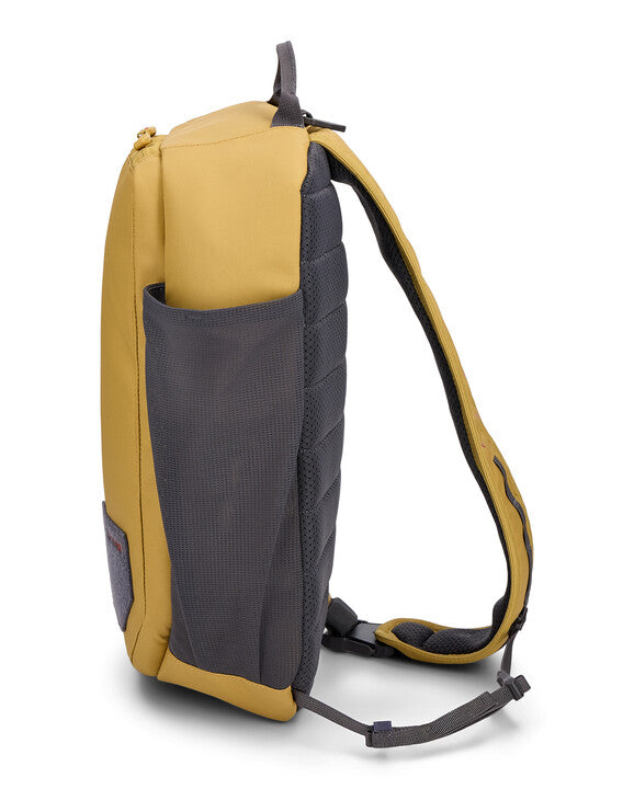 Simms Tributary Sling Pack in tan and gray, featuring a padded back, adjustable strap, and side mesh pocket, designed for convenient carry of fishing tackle and gear.