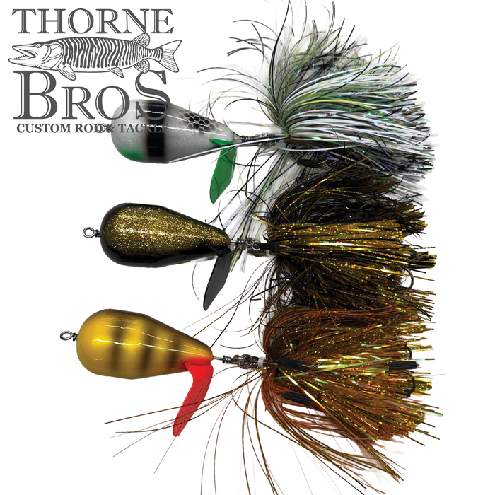 Image showing three fishing lures with colorful, detailed skirts and small propellers, designed for musky fishing, labeled Spanky Baits Violence and displayed next to the Thorne Bros custom rod and tackle logo.