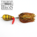 Spanky Baits Violence fishing lure with a gold and red body, featuring an orange and gold skirt, designed for musky fishing and displayed with Thorne Bros branding.