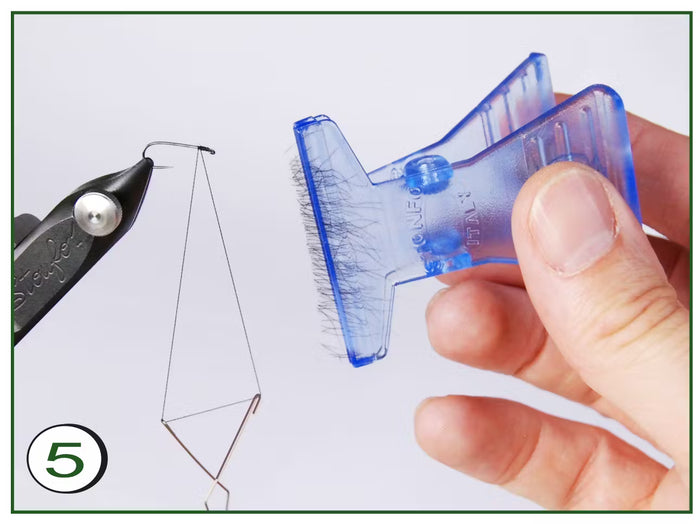 Hand holding a translucent blue Stonfo CDC Feathers Block tool next to fishing line tension device used for organizing delicate fishing feathers and materials.