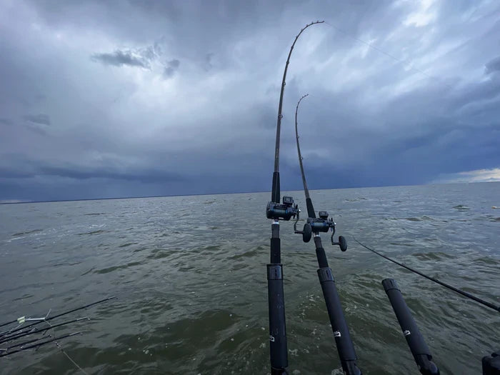 Two Thorne Bros F90M-BK-Trolling Blank fishing rods with reels set up on a boat over choppy water under a cloudy sky, ideal for trolling fishing.