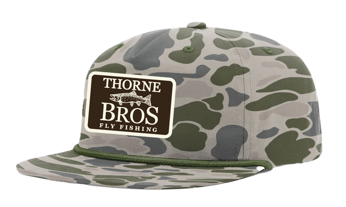 Thorne Bros Fly Fishing Trout Logo Richardson Umpqua 256P Olive Green hat featuring a camouflage pattern with an adjustable snapback and a rectangular Thorne Bros Fly Fishing patch on the front.