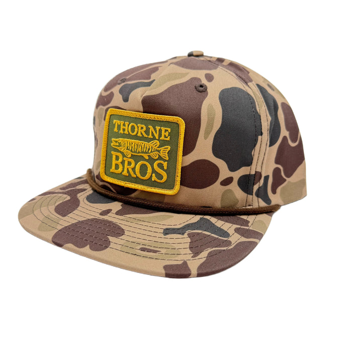 Thorne Bros Richardson 256P Thorne Bros. Patch camouflage-patterned fishing cap with a square yellow patch featuring the Thorne Bros. logo and fish graphic on the front.
