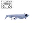 White soft plastic fishing lure with textured body, large black eye, and two treble hooks, identified as Trophy Systems Bait Co. 10" Osprey for musky fishing.