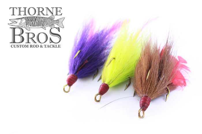 Three Windels Tied Trebles 5/0 Hook fishing lures with colorful feathers in purple, yellow, and brown, displayed on a white background with Thorne Bros branding.