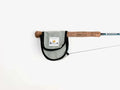Yakoda Reel Cover in silver gray fabric with black trim, designed to protect fishing reels, shown attached to a fly fishing rod with cork handle.